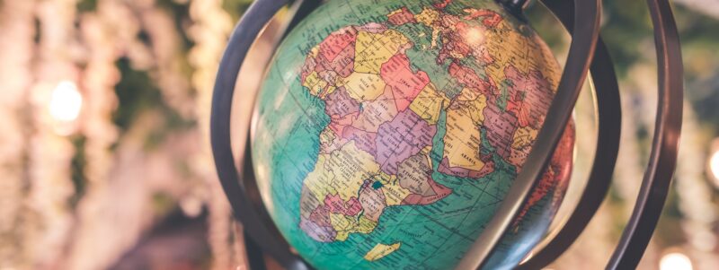 Globe with Africa featured, encircled by metal rings and lights behind it