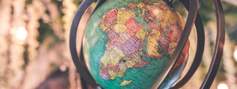 Globe with Africa featured, encircled by metal rings and lights behind it