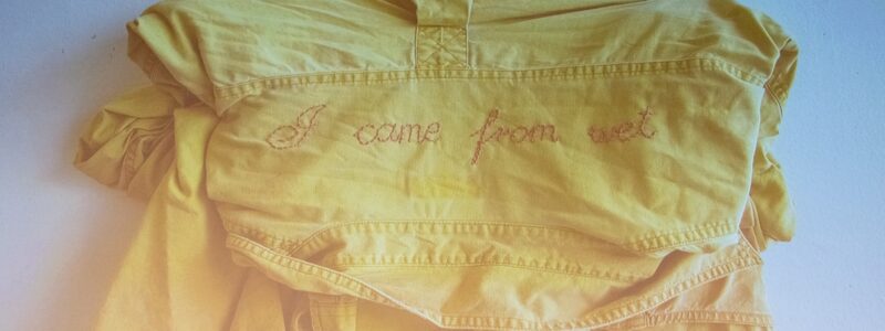 A yellow shirt embroidered on the back with the words 